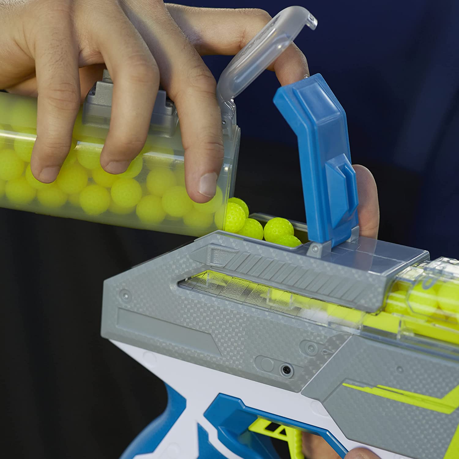 Remplissage de la trémie ouverte du Nerf Hyper Rush-40 avec des billes jaunes