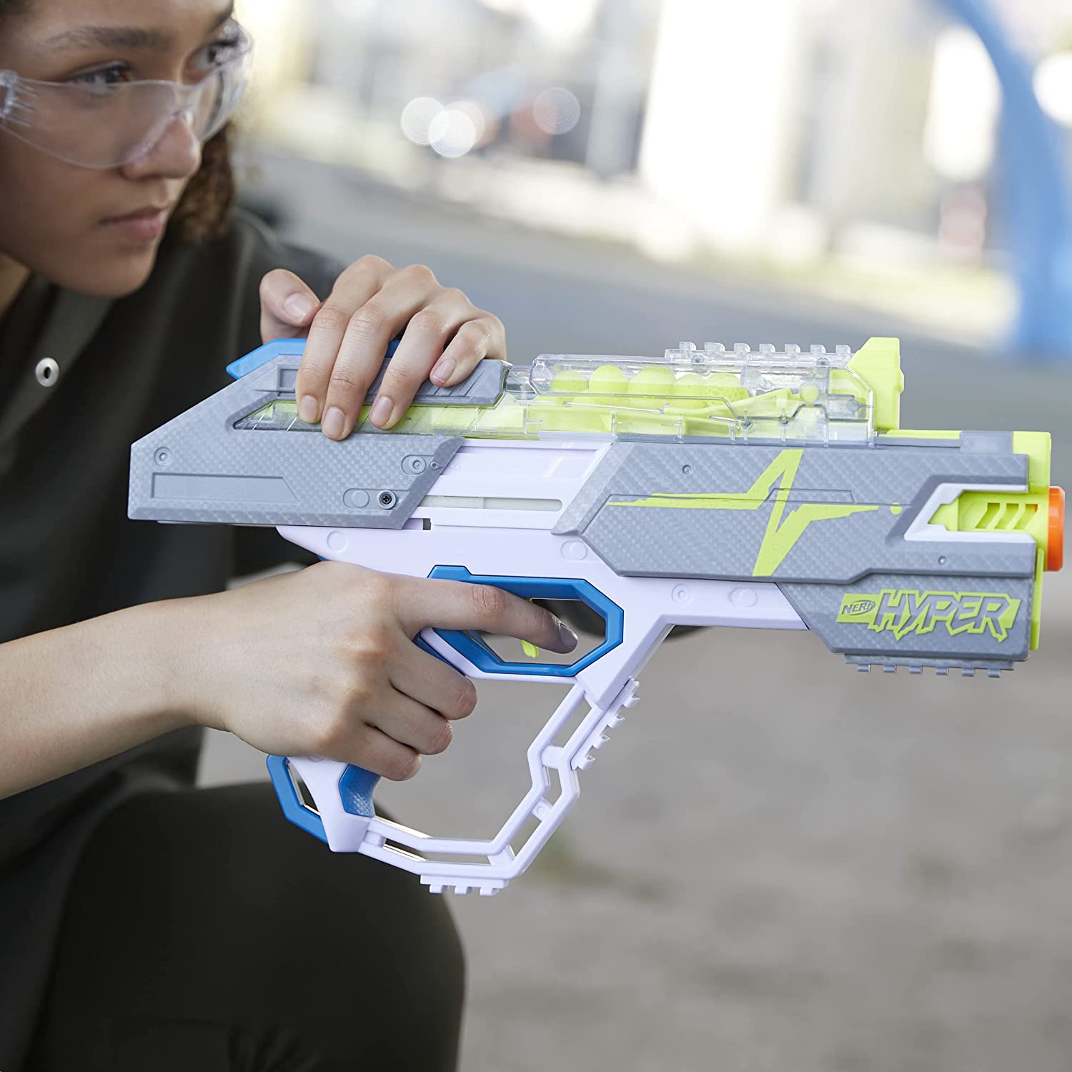 Utilisatrice actionnant la glissière supérieure du Nerf Hyper Rush-40 avec des lunettes de protection